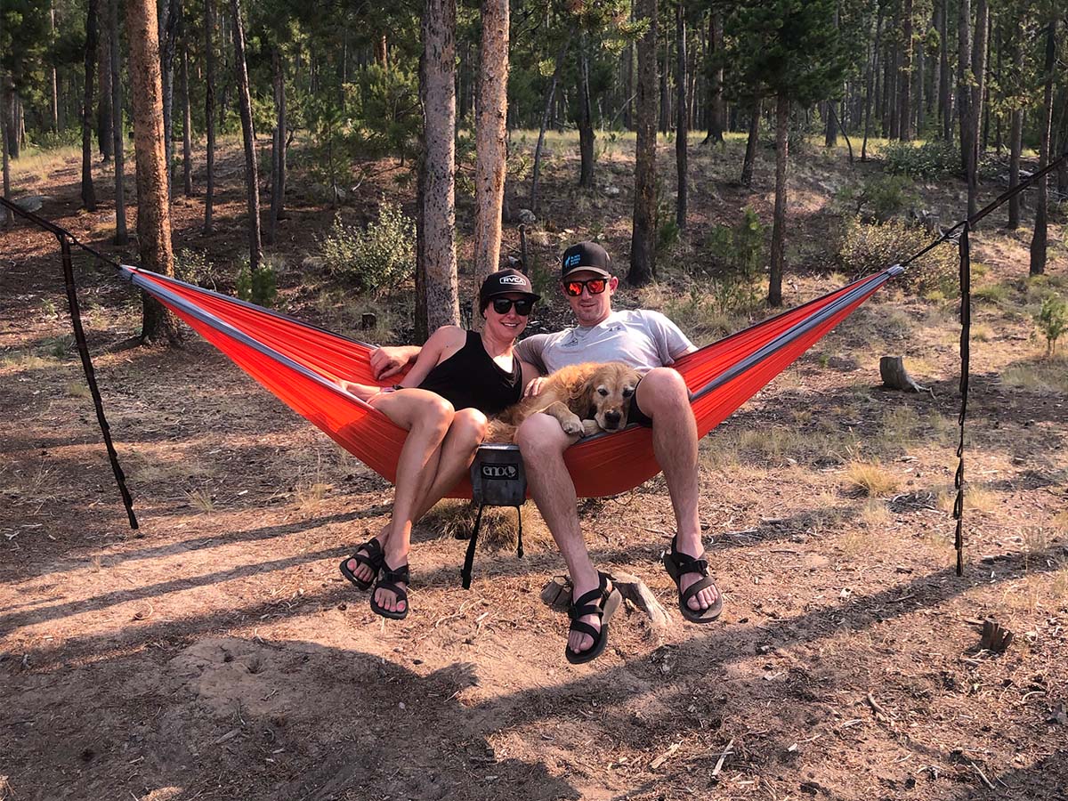 Nikki, Ryan and Cooper in hammock at camp